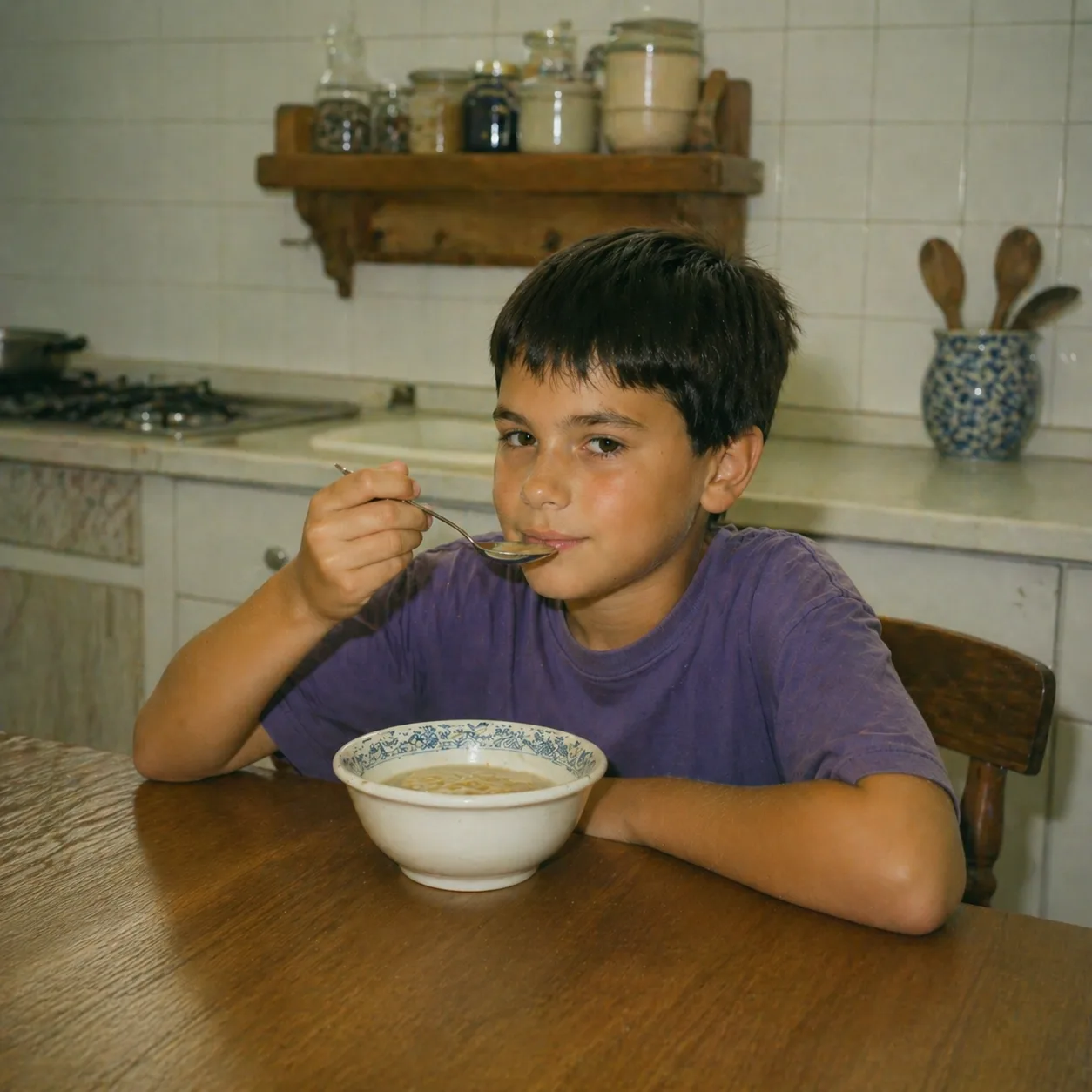 Nino comiendo sopa en una cocina